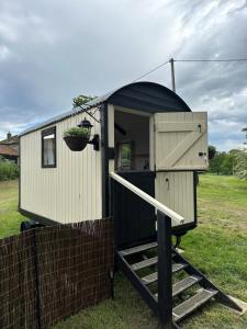 una casa pequeña con una rampa que conduce a una puerta en The Hideaway en Fakenham