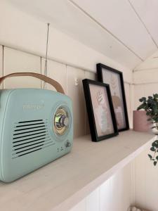 a radio sitting on a shelf with two pictures at The Hideaway in Fakenham