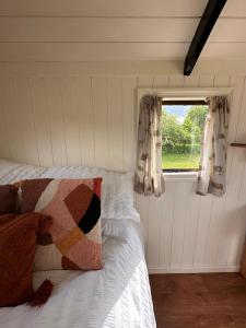 a bedroom with a bed and a window with curtains at The Hideaway in Fakenham