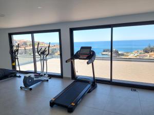 a gym with two exercise bikes and a view of the ocean at Stunning Lobos View in Câmara de Lobos