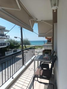 a balcony with a table and chairs and the ocean at Antonis apartment in Paralia Dionysiou