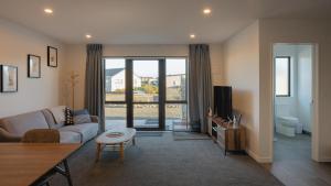 a living room with a couch and a tv at Entire Unit - 18 Rodman - newly furnished in Lake Tekapo