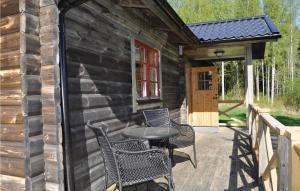 um pátio com cadeiras e uma mesa ao lado de um camarote em Stunning Home In Lngserud With 3 Bedrooms, Jacuzzi And Sauna em Rullan
