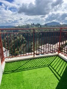 a balcony with green grass and a view at Emerald Avenue Cozy 3R3B Apartment 716 in Brinchang