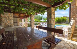 a wooden bench on a patio with a pool at Holiday Home Nedescina Nedescina in Nedeščina