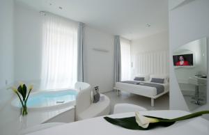 Cette chambre blanche comprend un lit et un lavabo. dans l'établissement Mia Boutique Hotel, à Milan
