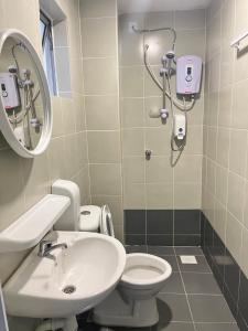 ein Badezimmer mit Waschbecken, Toilette und Spiegel in der Unterkunft Emerald Avenue Cozy 3R3B Apartment 716 in Brinchang + 14 Fotos