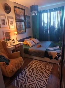 a bedroom with a bed and a chair and a window at Atrakcyjny apartament z dużym ogrodem in Gdańsk