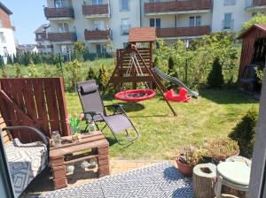 einen Hinterhof mit Spielplatz mit Spielgeräten in der Unterkunft Atrakcyjny apartament z dużym ogrodem in Danzig