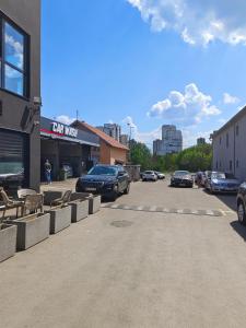 un estacionamiento con autos estacionados frente a un edificio en H.T Hotel en Belgrado