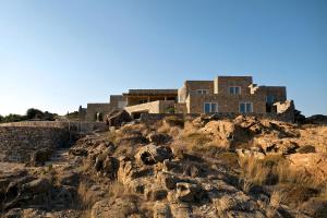 a building on the side of a rocky mountain at Liberation Villa in Kalafatis