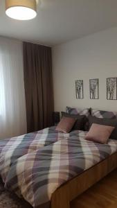 - une chambre avec un lit et une couverture tressée dans l'établissement Sarajevo New Apartments, à Sarajevo
