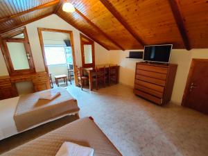a large room with two beds and a television at Port view Studios in Vathi