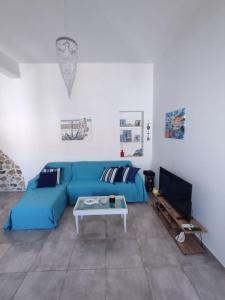a living room with a blue couch and a table at Sunrise Apartments - Aegean Blue in Kalymnos