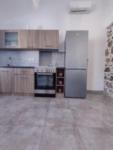 uma cozinha com um frigorífico e um fogão em Sunrise Apartments - Aegean Blue em Calímnos