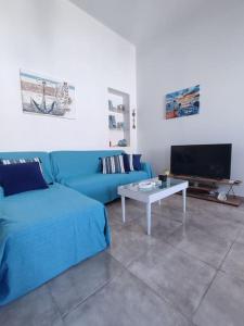 a living room with a blue couch and a table at Sunrise Apartments - Aegean Blue in Kalymnos