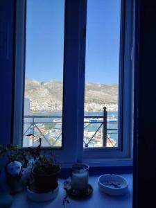 a room with a window with a view of the ocean at Sunrise Apartments - Aegean Blue in Kalymnos