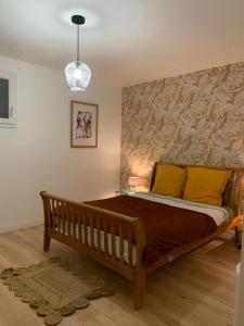 a bedroom with a large wooden bed with yellow pillows at Gîte du Triskell Le Domaine de Coat Rogan in Pommerit-Jaudy
