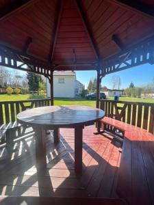 a picnic table and benches in a gazebo at Ośrodek Wczasowy Camping Morski in Ustka