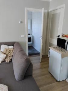 a living room with a gray couch and a kitchen at B&B de Maalderi-je in Winterswijk +7 photos