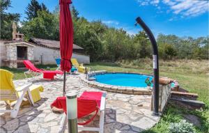 a patio with a pool and chairs and an umbrella at Awesome Home In Santalezi With Wifi in Santalezi