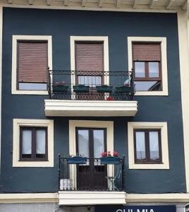 - un bâtiment bleu avec un balcon fleuri dans l'établissement Taraska I & II, à Bermeo