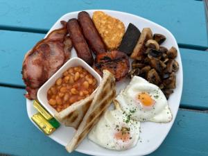 a plate of breakfast food with eggs sausage beans and toast at Hughie Mickey Dan's B&B 