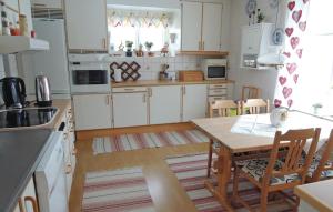 eine Küche mit weißen Schränken und einem Holztisch in der Unterkunft Awesome Home In Grimstorp With 3 Bedrooms in Grimstorp