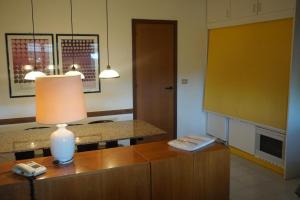 una habitación con una mesa y una lámpara en un armario en Punta Ala Boboli Apartment, en Punta Ala