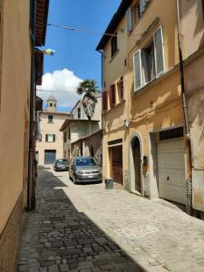 an alley with a car parked on a street at A casa di Rita in Città di Castello