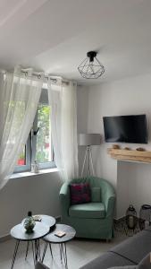a living room with a green couch and a window at Nina’s Garden in Loutraki