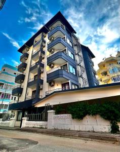 un gran edificio de apartamentos con balcones en un lateral. en Best Alanya Hotel, en Alanya