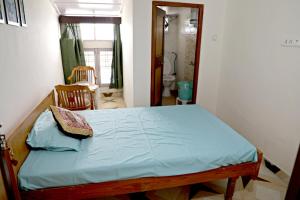 ムスーリーにあるBelleview Homestayのベッドルーム1室(青いシーツが付いたベッド1台付)