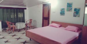 ムスーリーにあるBelleview Homestayのベッドとテーブルと椅子のある寝室