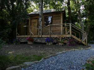 a cabin in the woods with flowers in front of it at Cosy Crann #Find Your Escape in Loughrea