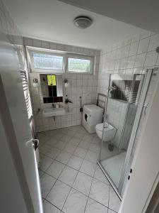 een badkamer met een toilet, een douche en een wastafel bij Ferienhaus mit großem Garten in Oldenburg