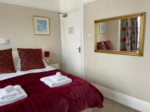 a bedroom with a bed with towels on it at The Sandrock in Clacton-on-Sea