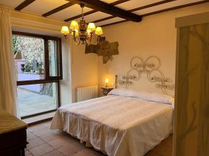 a bedroom with a bed and a chandelier at Casa Rural La Ferrería in Vinuesa