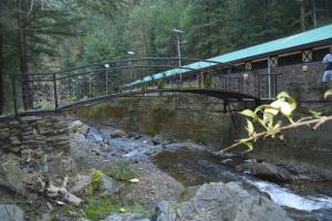 a bridge over a stream with people walking on it at Indu BNB Shimla in Shimla