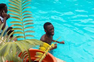 a man in a swimming pool with a paddle at Okaseni Lodge in Arusha