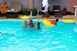 a group of people playing in a swimming pool at Okaseni Lodge in Arusha