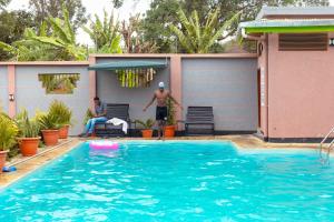 un uomo in piedi accanto a una piscina di Okaseni Lodge ad Arusha