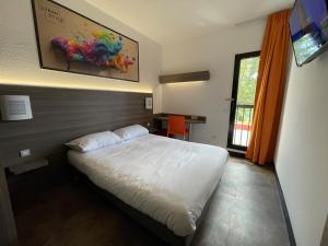 1 dormitorio con 1 cama y una pintura en la pared en Urban Style Cannes Mouans-Sartoux - Piscine Extérieure - Parking Gratuit en Mouans-Sartoux
