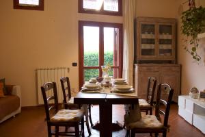 ein Esszimmer mit einem Tisch mit Stühlen und einem Fenster in der Unterkunft Appartamento Mandiri in San Casciano in Val di Pesa