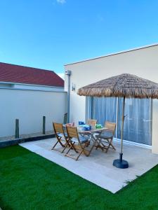 a patio with a table and chairs and an umbrella at Villa Contemporaine in Châtellerault