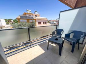 een balkon met 2 stoelen en een tafel. bij On Family Islantilla in Islantilla