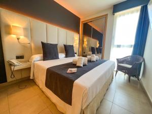 a hotel room with a large bed with a window at On Family Islantilla in Islantilla