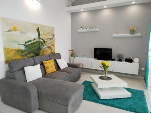 a living room with a couch and a tv at Apartman La Marija in Prizba