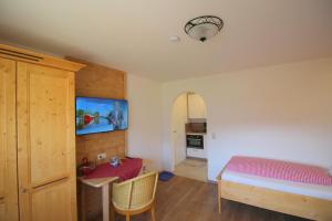 a bedroom with a bed and a table and a tv at Leitnerhof in Bad Reichenhall