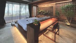 a bedroom with a large bed and a desk with at SANTI beach retreat in Ban Rang Pla